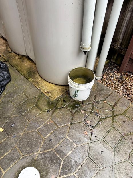 Standing water collecting beside the water tank outside the home