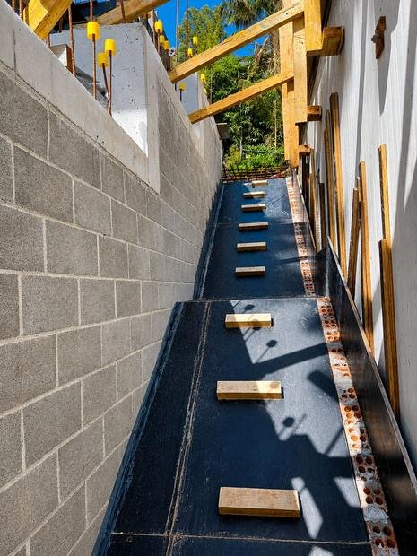 Barrier membrane detailed against a block retaining wall