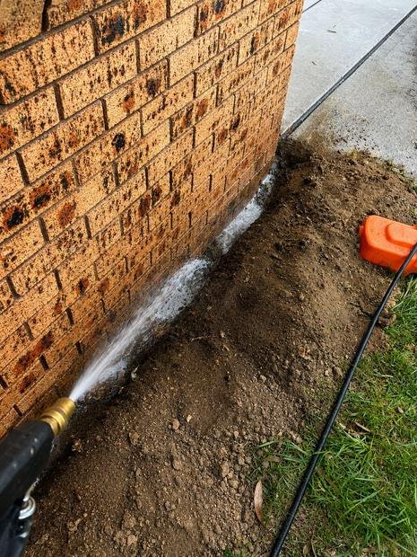 Chemical soil barrier applied along a brick footing